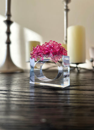 Decorative table setting with a pink acrylic blossom napkin ring on toile de jouy patterned napkin