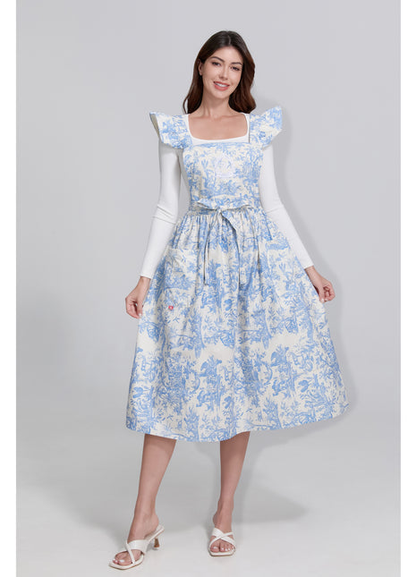 Model wearing a blue toile de jouy  floral dress on a gray background