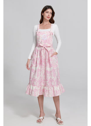 Model wearing a pink toile de jouy floral apron with a gray background