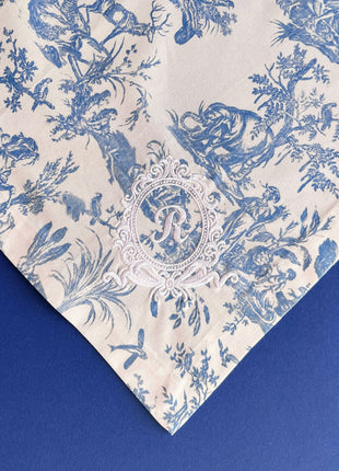 Blue toile de jouy floral patterned napkins with royal emblem embroidery