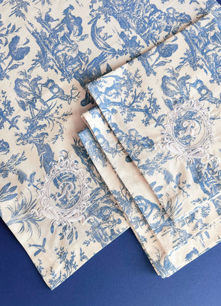 Blue toile de jouy floral patterned napkins with royal emblem embroidery