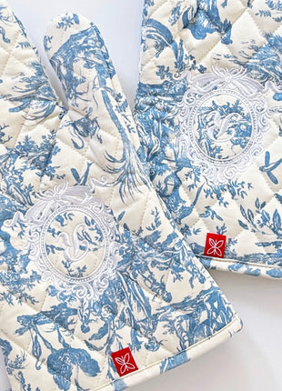 Pair of blue toile de jouy patterned ovenmitts with royal emblem embroidery 