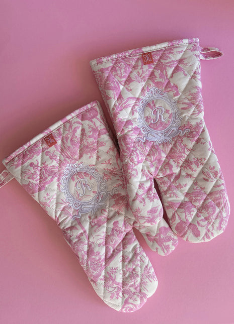 Pair of pink toile de jouy patterned ovenmitts with royal emblem embroidery 
