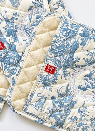 Pair of blue toile de jouy patterned pot holders with royal emblem embroidery 