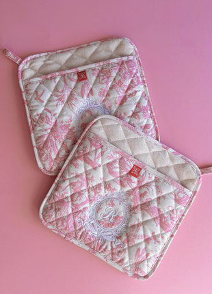 Pair of pink toile de jouy patterned pot holders with royal emblem embroidery