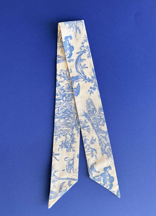 Blue toile de jouy patterned twilly, headband, and tie.