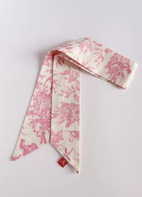 Pink toile de jouy patterned twilly, headband, and tie.